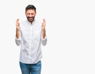 Adult hispanic man over isolated background smiling crossing fingers with hope and eyes closed. Luck and superstitious concept.