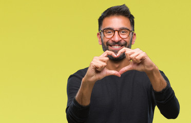Adult hispanic man wearing glasses over isolated background smiling in love showing heart symbol and shape with hands. Romantic concept.