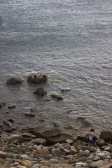 Photographer taking pictures of transparent water ocean and pebble