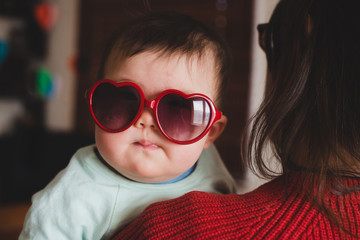 Cute baby in big heart sunglasses