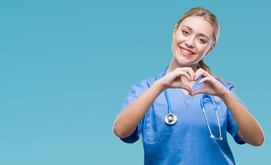 Young blonde surgeon doctor woman over isolated background smiling in love showing heart symbol and...