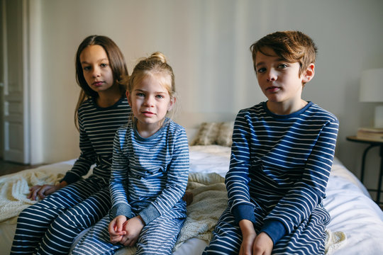 Portrait of kids wearing pajama resting on bed. 