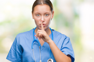 Young caucasian doctor woman wearing medical uniform over isolated background asking to be quiet...