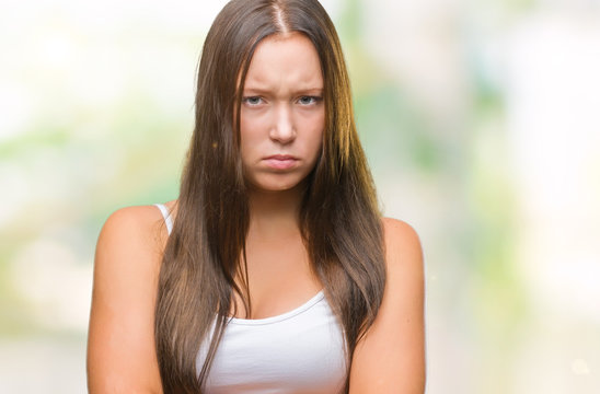 Young caucasian beautiful woman over isolated background skeptic and nervous, disapproving expression on face with crossed arms. Negative person.