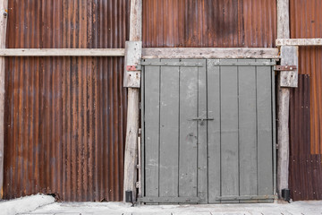 Obraz na płótnie Canvas Big wooden door and rusted zinc wall