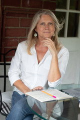 Blonde mature woman smiling with notebook