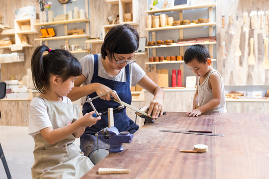 Asian womant with her kid doing carpenter job in the studio
