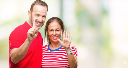 Fototapeta premium Middle age hispanic couple in love over isolated background showing and pointing up with fingers number six while smiling confident and happy.