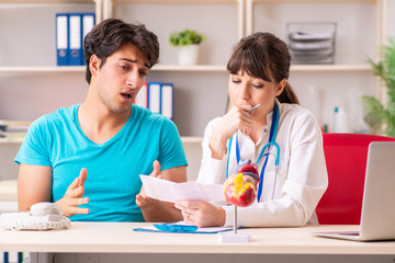 Obraz premium Young man visiting female doctor cardiologist 
