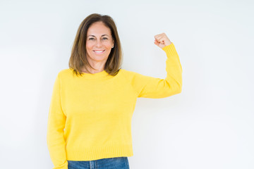 Beautiful middle age woman wearing yellow sweater over isolated background Strong person showing arm muscle, confident and proud of power