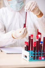 Young handsome lab assistant testing blood samples in hospital 