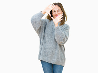 Beautiful middle age woman wearing winter sweater over isolated background Smiling doing frame using hands palms and fingers, camera perspective
