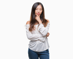 Young asian woman over isolated background looking confident at the camera with smile with crossed arms and hand raised on chin. Thinking positive.