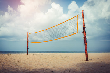 Volleyball court on an empty beach with blue cloudy sky.  Vintage tone.