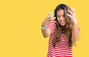 Young beautiful brunette woman wearing stripes t-shirt over isolated background Shouting frustrated with rage, hands trying to strangle, yelling mad