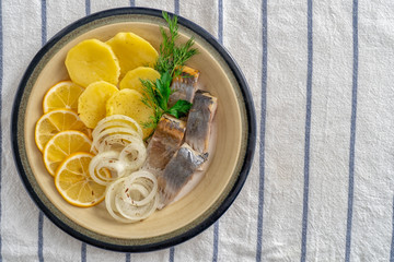 Sliced fish with potatos on plate