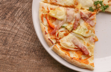 Hot pizza slice on wooden table