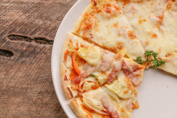 Hot pizza slice on wooden table
