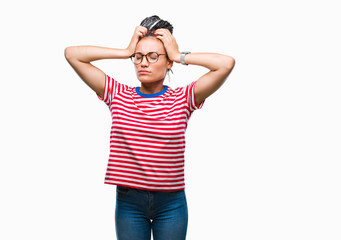 Young braided hair african american girl wearing glasses over isolated background suffering from headache desperate and stressed because pain and migraine. Hands on head.