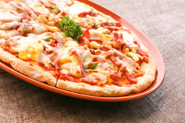 Hot pizza slice on wooden table