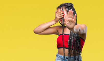 Young braided hair african american with pigmentation blemish birth mark over isolated background covering eyes with hands and doing stop gesture with sad and fear expression. Embarrassed