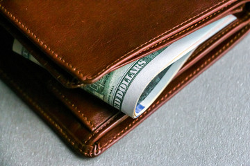 Closeup view of wallet with one hundred and fifty dollar banknotes.