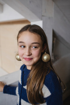 Portrait of little girl with Christmas decorations like earrings