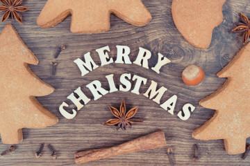 Gingerbreads, inscription Merry Christmas and ingredients for baking. Vintage photo
