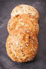 Wholegrain homemade rolls with seeds on dark background