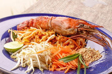 Hot Pad thai with shrimp on wooden table