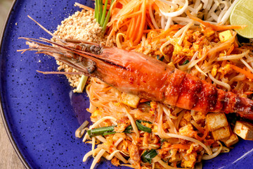 Hot Pad thai with shrimp on wooden table