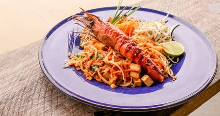 Hot Pad thai with shrimp on wooden table