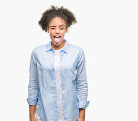 Young afro american woman over isolated background sticking tongue out happy with funny expression. Emotion concept. © Krakenimages.com