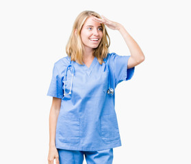 Beautiful young doctor woman wearing medical uniform over isolated background very happy and smiling looking far away with hand over head. Searching concept.