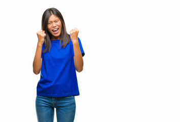 Young asian woman over isolated background very happy and excited doing winner gesture with arms raised, smiling and screaming for success. Celebration concept.