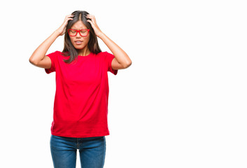 Obraz na płótnie Canvas Young asian woman wearing glasses over isolated background suffering from headache desperate and stressed because pain and migraine. Hands on head.