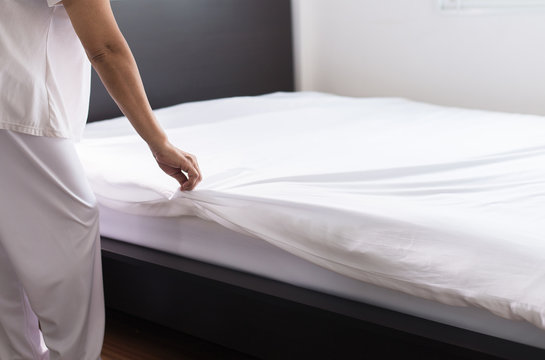 Woman make a bed,Female making white bed in room after wake up at home