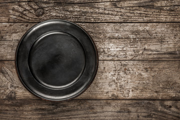 Old natural wooden background or texture with empty plate. Wood table, top view, flat lay, space for text