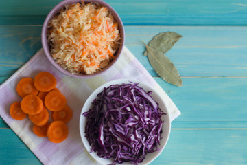 Photo of cabbage and carrot salad and salad of purple cabbage on a bright blue background.