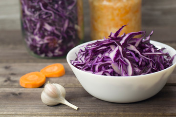 Photo of the salad of purple cabbage close-up on a wooden background.