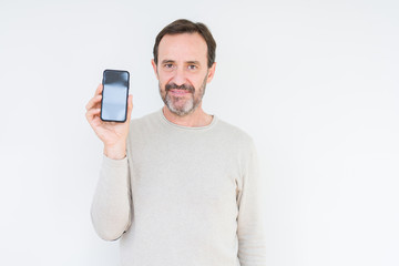 Senior man showing smartphone screen over isolated background with a confident expression on smart face thinking serious