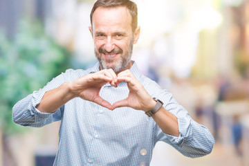 Middle age hoary senior business man over isolated background smiling in love showing heart symbol and shape with hands. Romantic concept.
