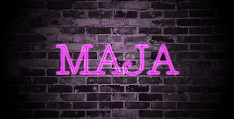 first name Maja in pink neon on brick wall