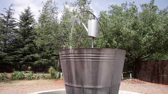Wide pan right reveal of water can water feature