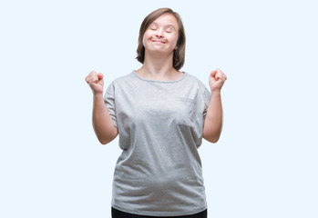 Fototapeta na wymiar Young adult woman with down syndrome over isolated background celebrating mad and crazy for success with arms raised and closed eyes screaming excited. Winner concept