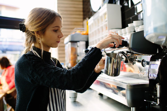 Concentrated pretty barista making coffee