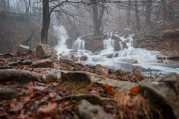 little waterfalls in rainy autumn forest