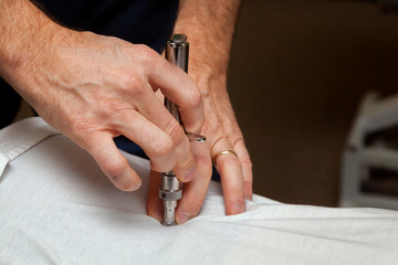 Hands of a Chiropractor Using an Integrator to Adjust the Spine of a Patient