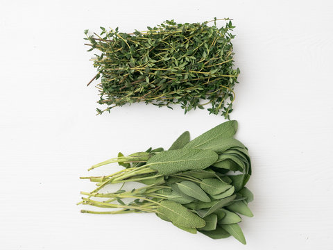 Holiday poultry herbs. Sage and thyme on white wood.