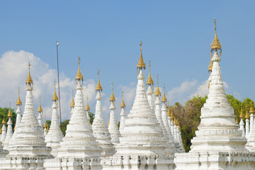 White stupas Sandarmuni Pagoda on a sunny day. Mandalay, Burma